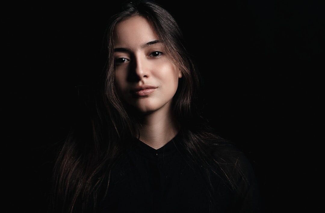 Studio portrait of a young woman with straight dark hair