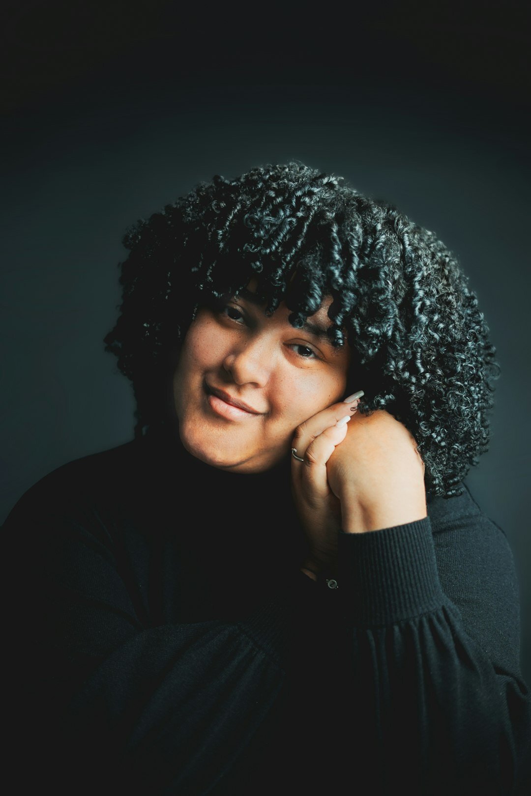 Studio portrait of a woman with curly hair smiling