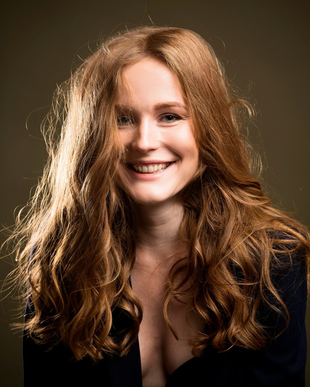 Studio portrait of a smiling woman with shoulder length hair