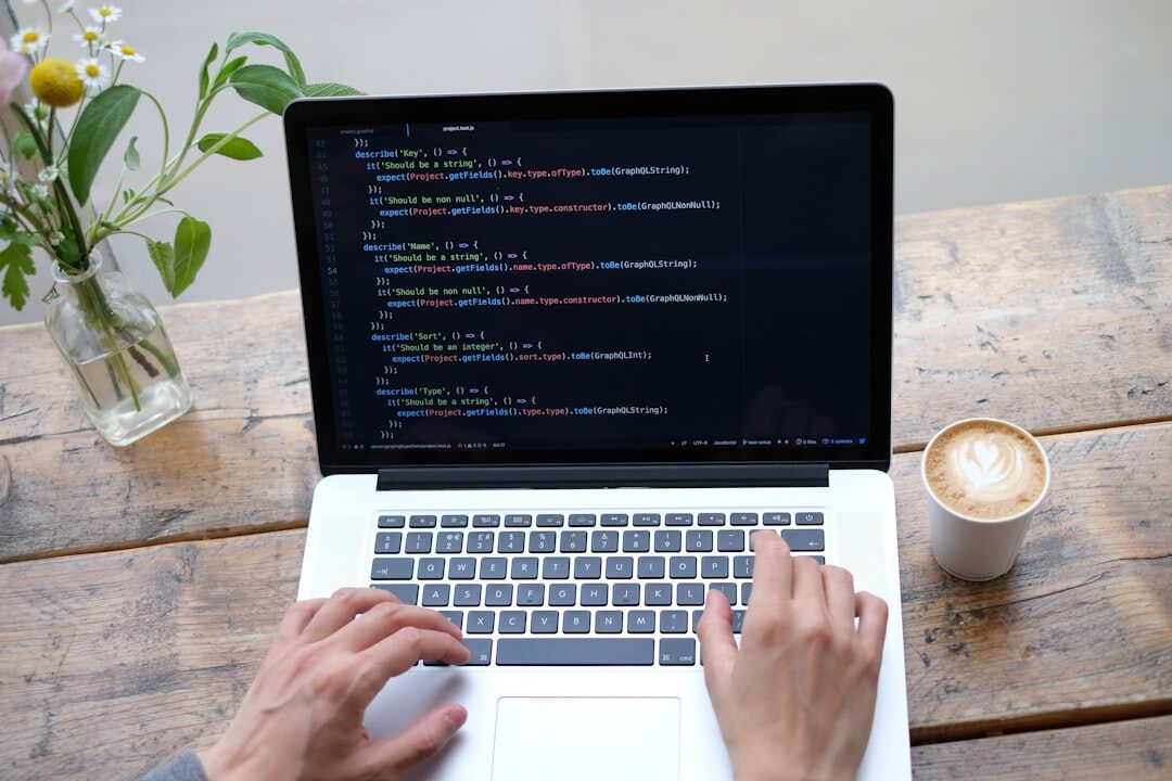 Person writing code on a laptop with colorful syntax highlighting