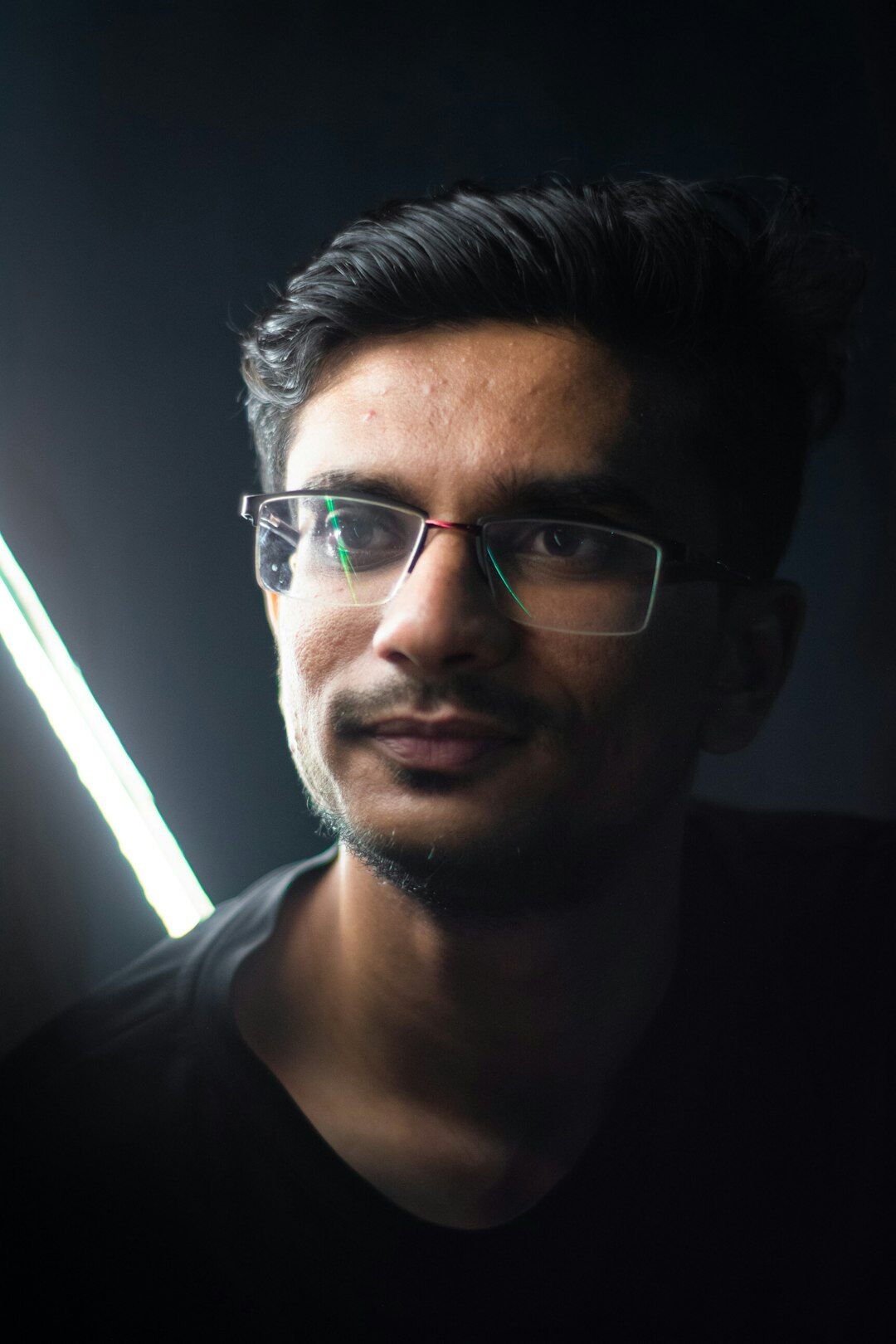 Studio portrait of a young man with glasses